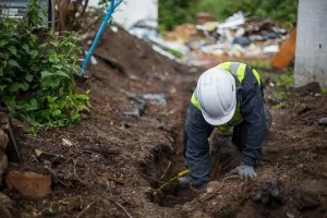 Świeżo wylana, gładka posadzka betonowa na jasnej budowie, w tle narzędzia i materiały wykończeniowe.